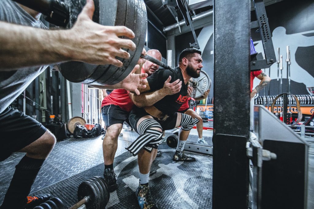 men lifting weights squat