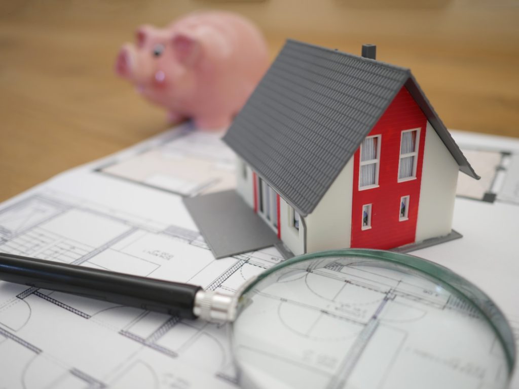 miniature house, piggy bank, magnifying glass, architecture plans